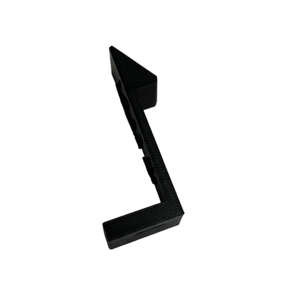 Black plastic component on a white surface